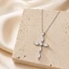 silver cross necklace on stone display