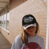 One way Jesus hat on girl in front of brick wall Swanson christian