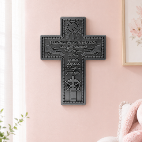 wall cross hanging on a pink wall