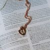 Rose gold-tone heart pendant necklace featuring a cross cutout resting on an open Bible. The warm metallic finish and visible Scripture create a meaningful faith-centered composition that symbolizes Christ’s love, redemption, and devotion. A beautiful Christian jewelry gift for women, perfect for encouragement, birthdays, confirmations, Mother's Day, or everyday wear.