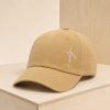 Tan Christian baseball cap with white embroidered “faith” lettering on the front, displayed on a light wood shelf with a simple neutral background.
