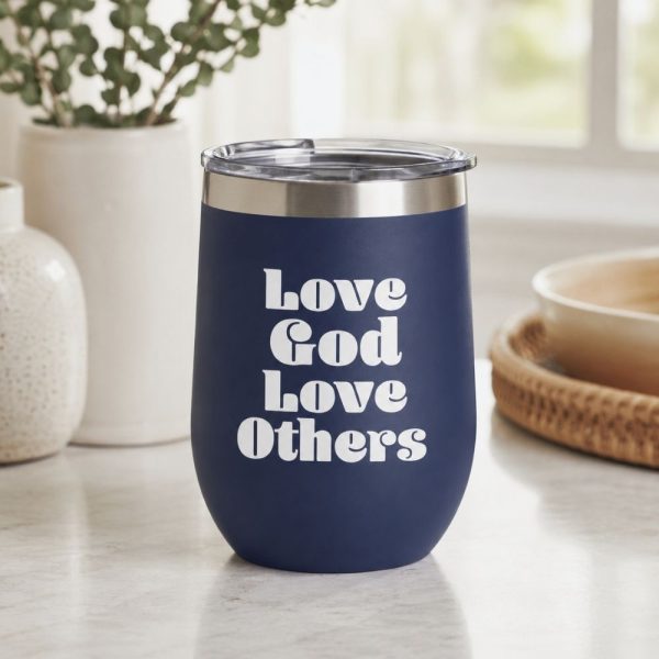 Navy blue insulated tumbler featuring a white “Love God Love Others” Christian vinyl decal, displayed on a bright kitchen countertop with neutral home décor.