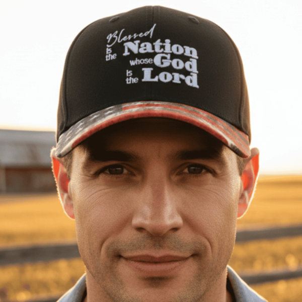 Man wearing ‘Blessed is the Nation whose God is the Lord’ Christian hat in outdoor rural setting, faith and patriotic apparel