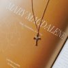 Delicate gold-tone cross necklace with crystal accents resting on a book featuring “MARY MAGDALENE,” creating an elegant faith-inspired scene that highlights devotion, grace, and the enduring message of God’s faithfulness.