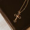 Elegant gold-tone cross necklace with a crystal accent resting on a dark leather Bible, creating a warm and timeless faith-centered scene. The rich leather texture and soft lighting highlight the necklace as a meaningful symbol of devotion, making it ideal for gift-giving, daily wear, or personal encouragement.