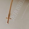 Gold-tone cross necklace resting on a faith-inspired journal featuring the word “JEHOSH...” and the phrase “God’s Faithfulness in Obscurity,” creating a peaceful Christian devotional setting.