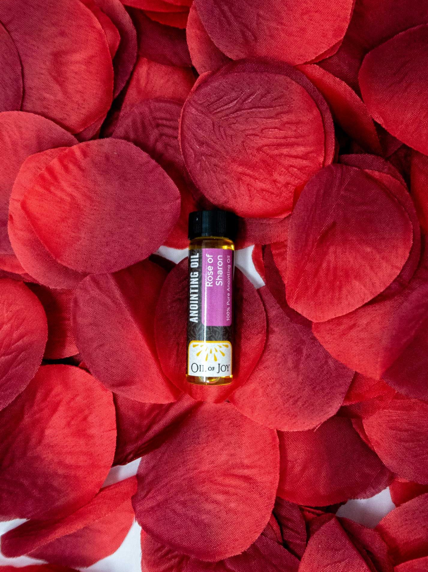 Rose of sharon anointing oil with rose petals background- oil of joy