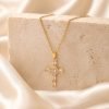 gold cross necklace on stone block
