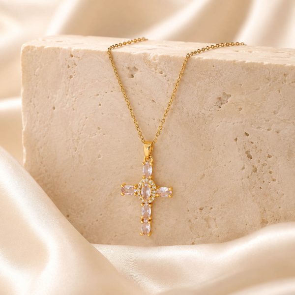 gold cross necklace on stone block