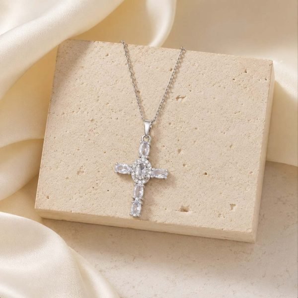 silver cross necklace on stone block